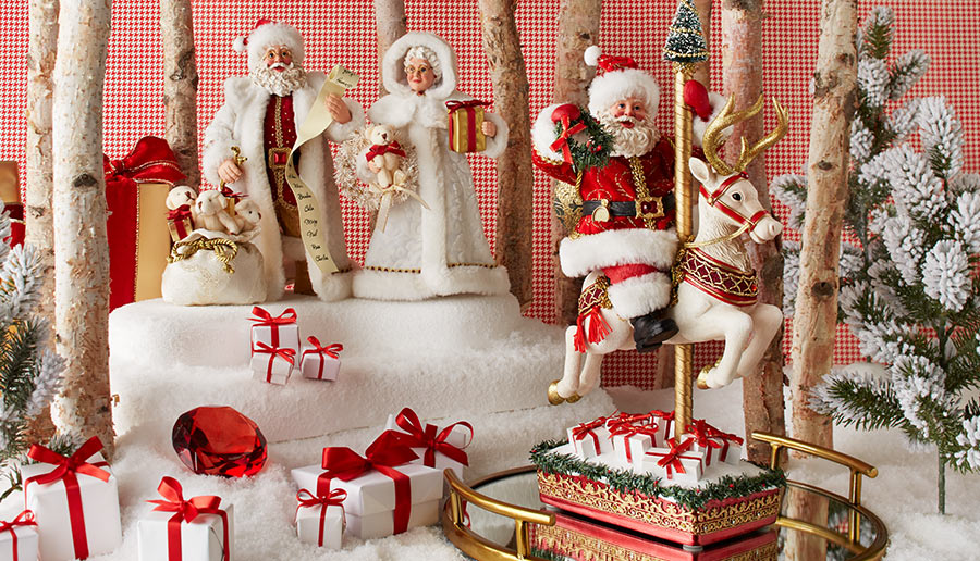 Decorative Christmas scene with Santa Claus, reindeer, and presents in a snowy setting.